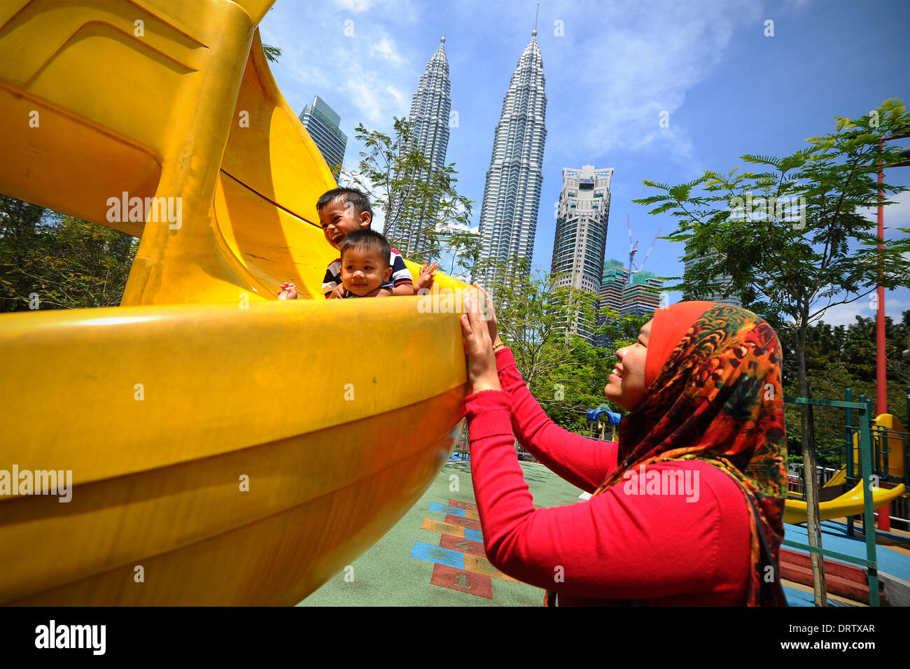 Kuala Lumpur, Malaysia. 1st Feb, 2014. A Muslim women looks on as her children plays at a playground during the second day of Chinese Lunar New Year in Kuala Lumpur, Malaysia, Saturday, February 1, 2014. In Malaysia, during religious festivities there is usually two days public holiday, which other ethnic races will enjoy the holidays. © Joshua Paul/NurPhoto/ZUMAPRESS.com/Alamy Live News Stock Photo