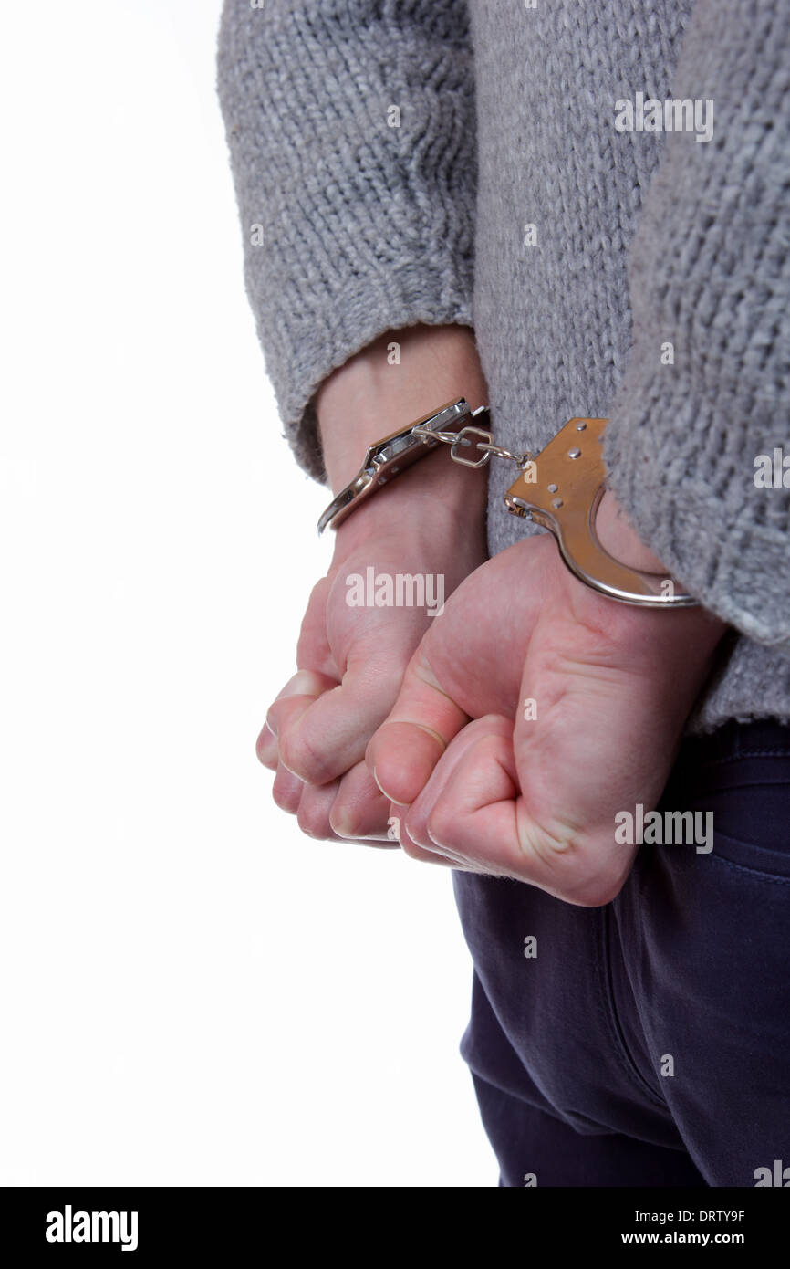 Teenager wearing handcuffs and is caught by the police Stock Photo