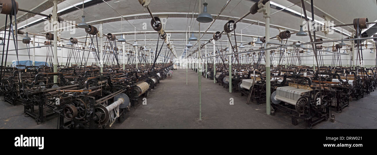 The many ranks of looms in the weaving shed at Queen Street Mill in Burnley, seen in panoramic view. Stock Photo