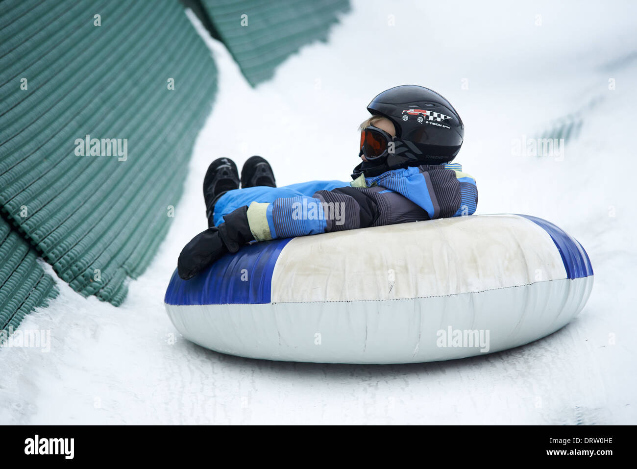 Young boy enjoys a snow tube ride Stock Photo Alamy