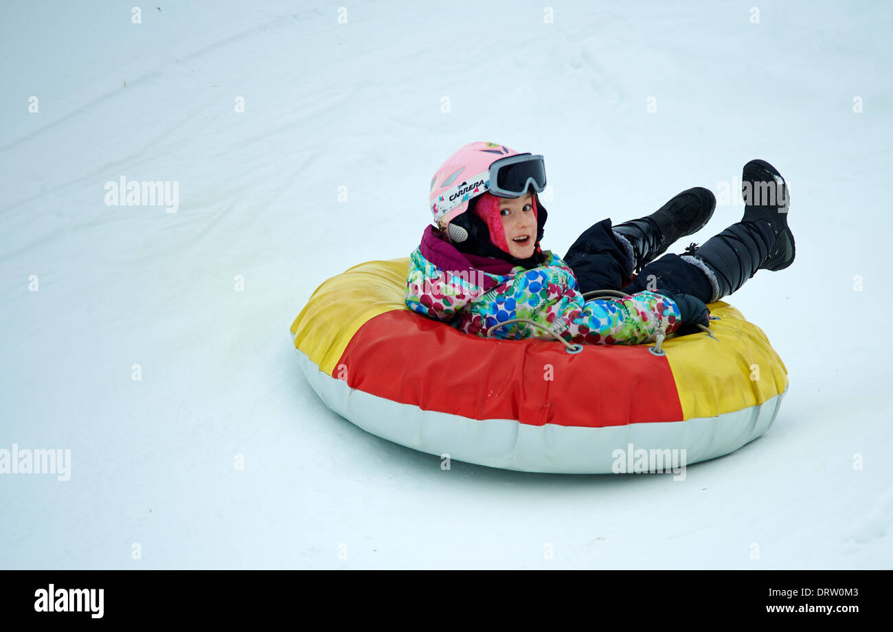 Young child girl enjoying snow tubing Stock Photo