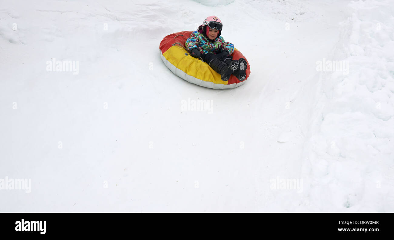 Young child girl enjoying snow tubing Stock Photo