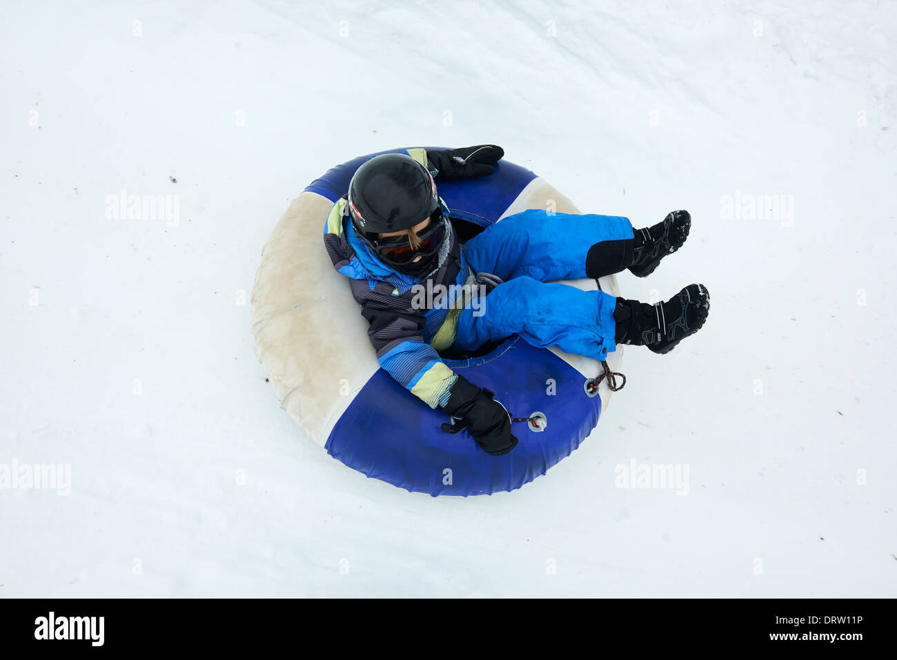 Young boy enjoys a snow tube ride Stock Photo Alamy