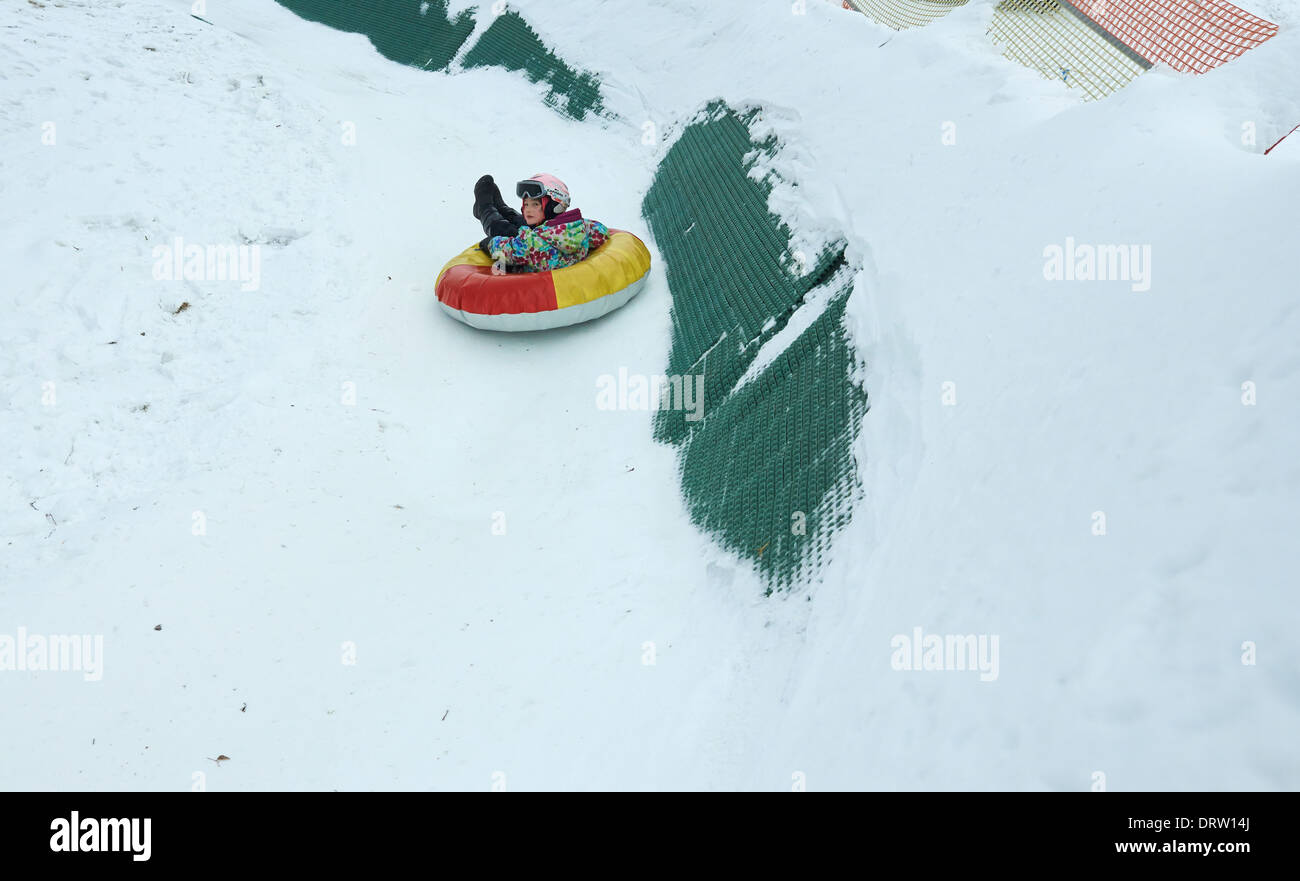 Young child girl enjoying snow tubing Stock Photo