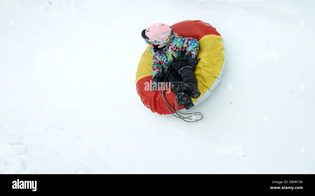 Young child girl enjoying snow tubing Stock Photo