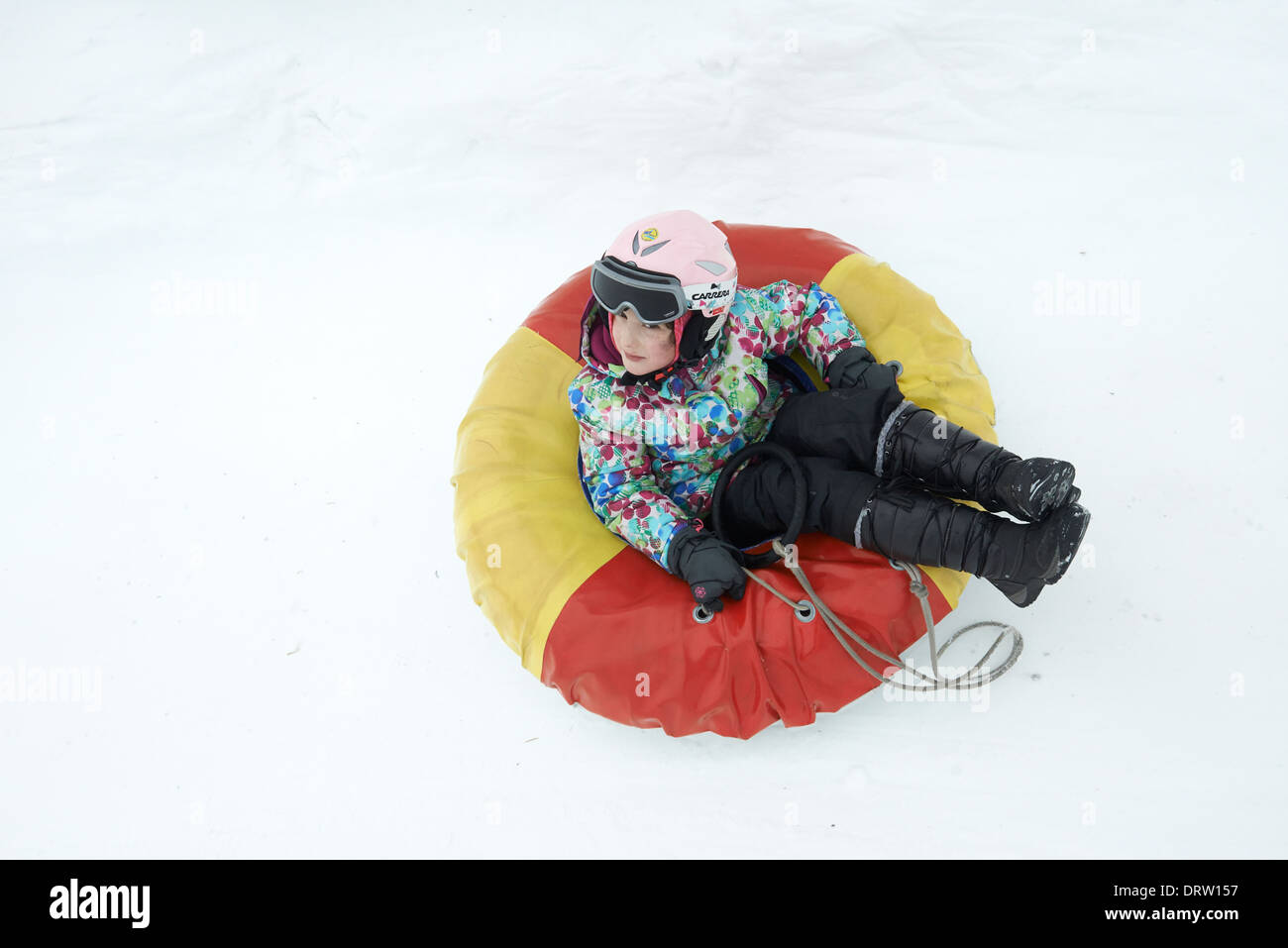 Young child girl enjoying snow tubing Stock Photo