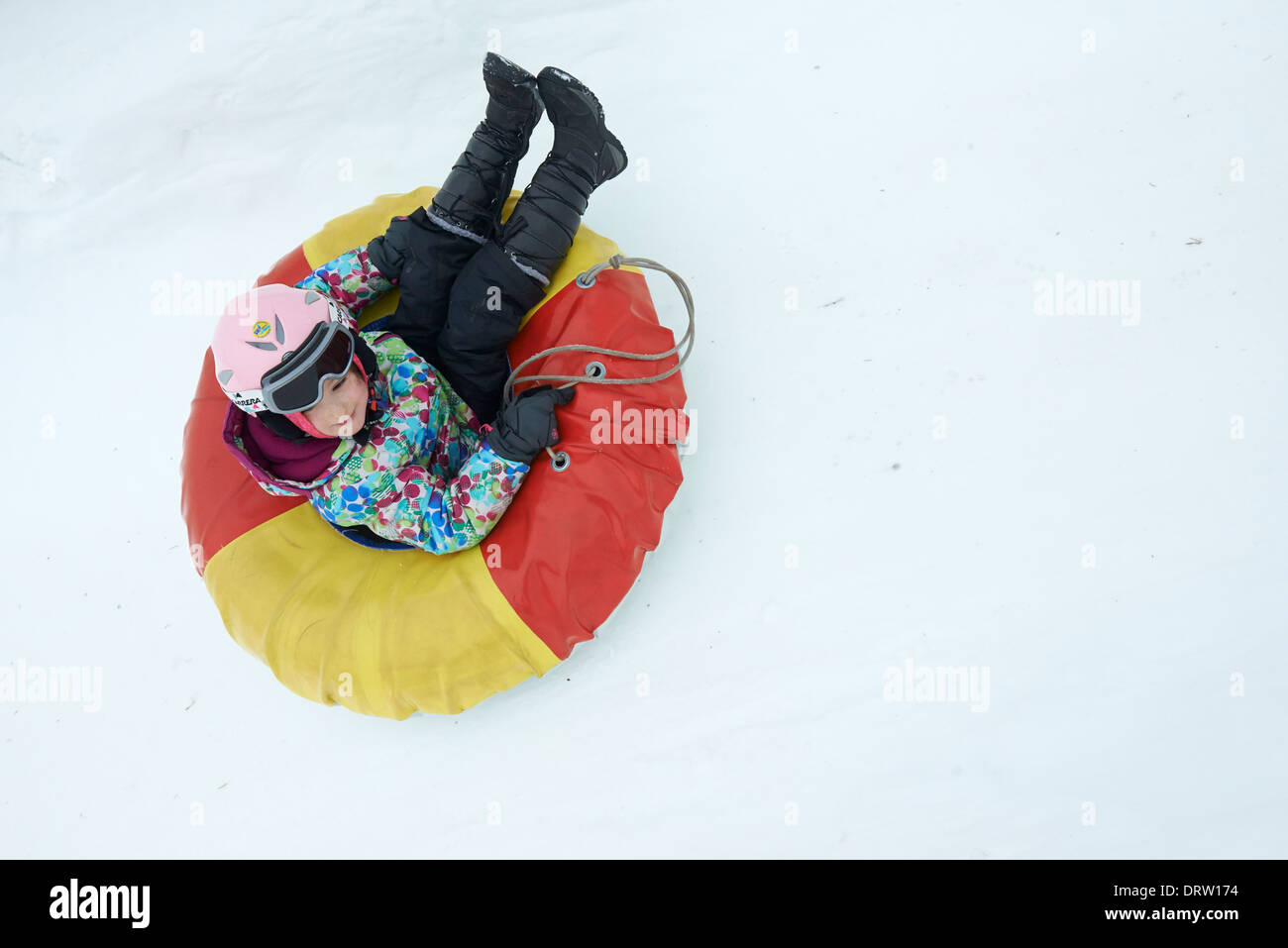 Young child girl enjoying snow tubing Stock Photo