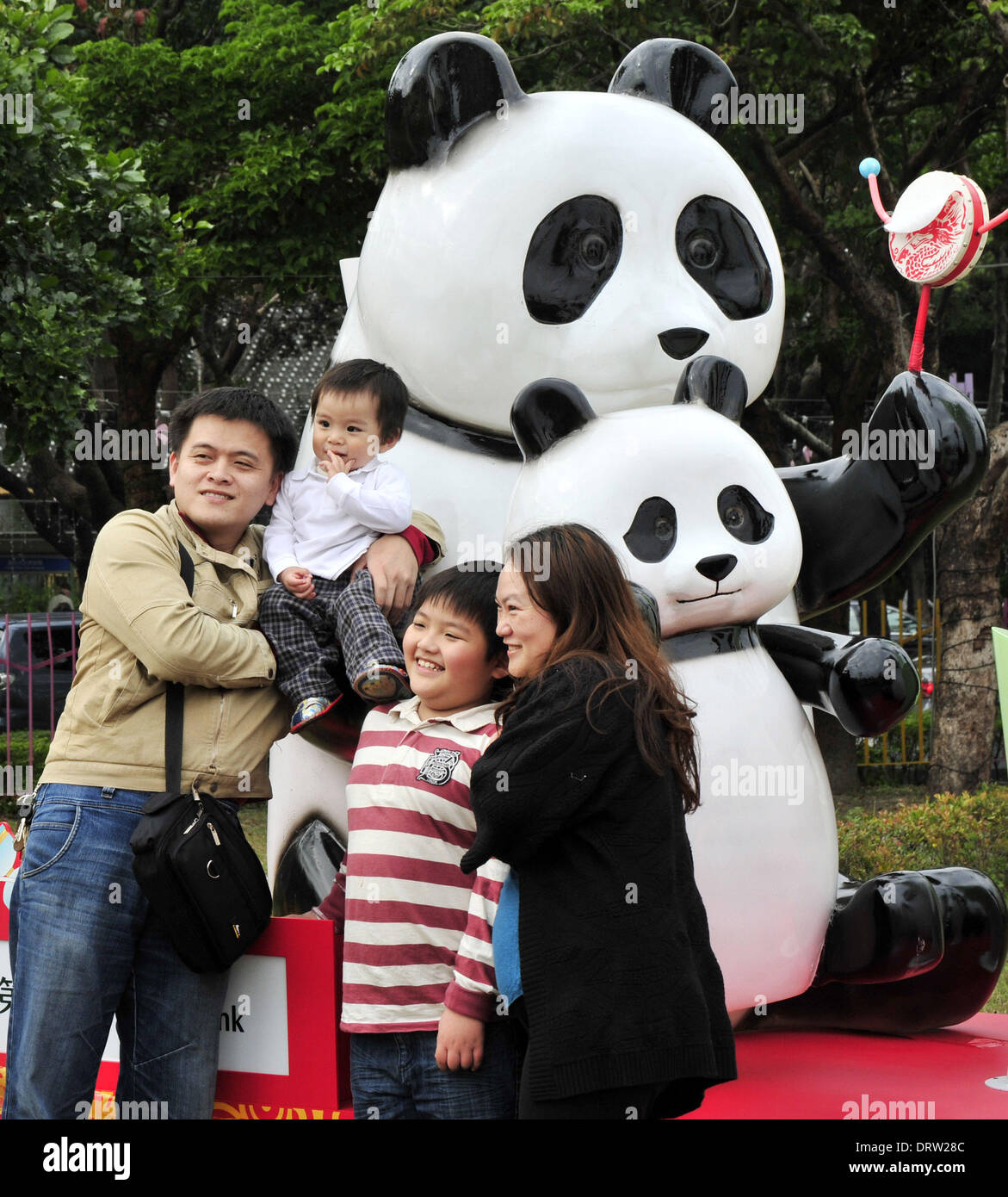 (140202) -- TAIPEI, Feb. 2, 2014 (Xinhua) -- Tourists pose for a photo in front of panda cub 'Yuanzai'-shaped models at the Taipei Expo Park in Taipei of southeast China's Taiwan, Feb. 2, 2014. (Xinhua/Wu Ching-teng) (cjq) Stock Photo