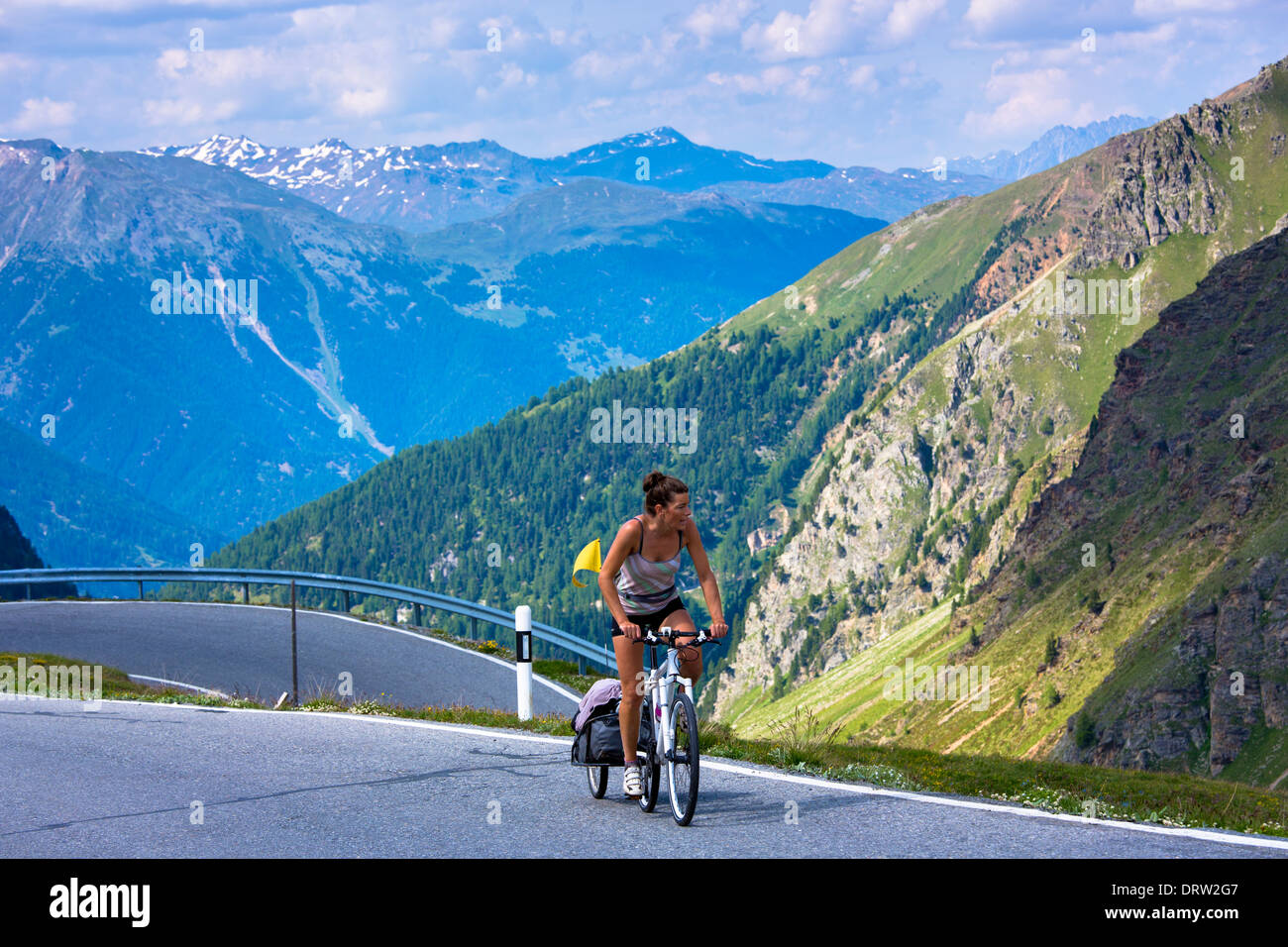 Female cyclist on the Umbrail Pass which leads, in the Swiss National Park, from Switzerland to Italy in the Eastern Alps Stock Photo