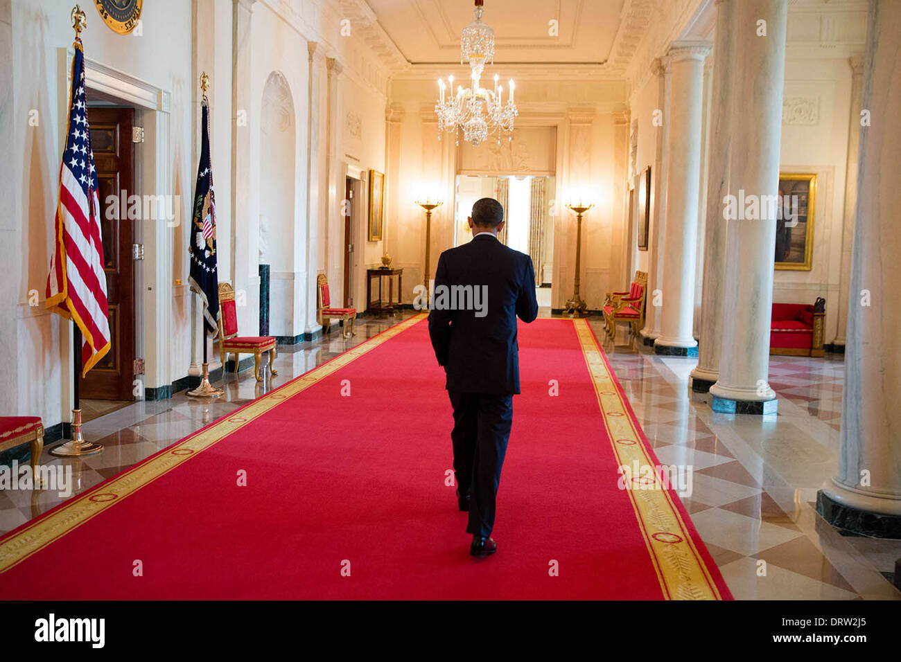 US President walks alone down the red carpet of the Cross Hall of the White House August 8, 2013 in Washington, DC. Stock Photo