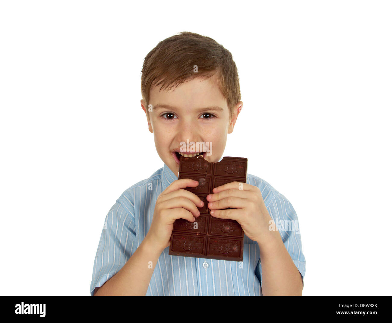 Smiling funny young kid eating chocolate.White isolated Stock Photo