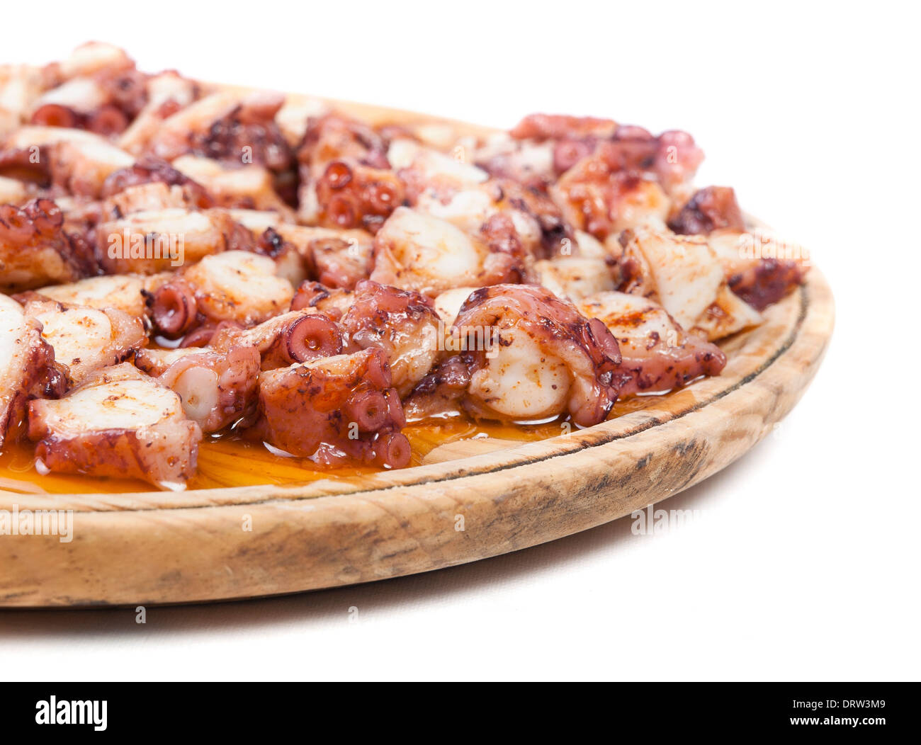 Pulpo a feira in a wooden plate and isolated on white background Stock Photo