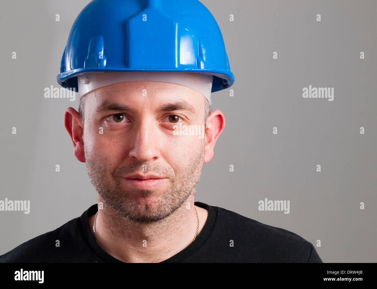 Portrait of a worker with serene expression and isolated on dark ...
