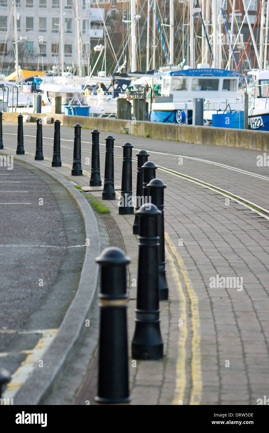 Curve in a road lined with bollards on the harbour side at Weymouth,Dorset. Stock Photo
