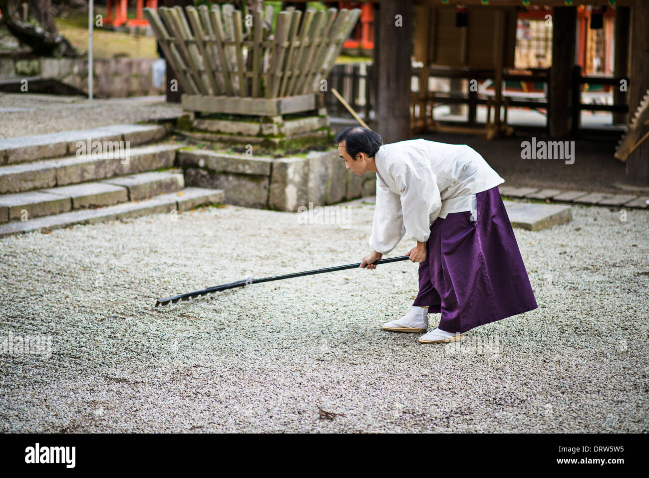 Japanese Shinto Priest rakes a Zen Garden. Stock Photo