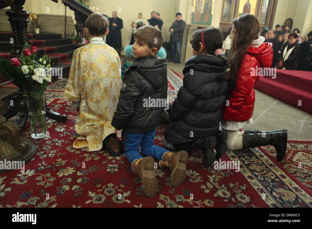 Children pray on bended knees during the ceremony of the enthronement of new Archbishop of Prague. Stock Photo