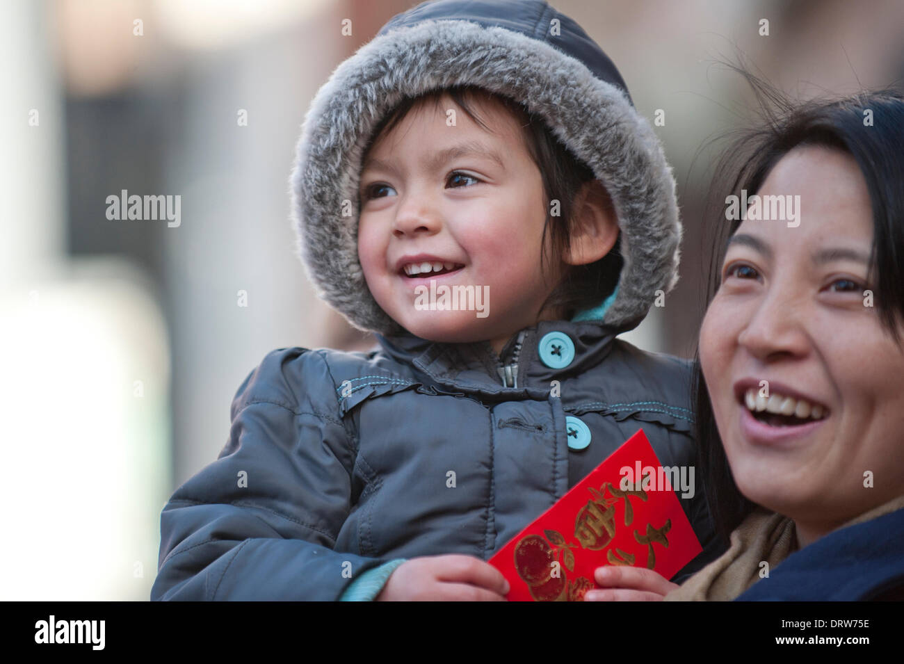 Manchester, UK. 2nd February 2014. A young spectator enjoys the celebration of Chinese New Year 2014 (the year of the Horse), which began with a parade in Albert Square led by a 175ft long dragon operated by the Master Chu Lion Dancing Club Credit:  Russell Hart/Alamy Live News. Stock Photo