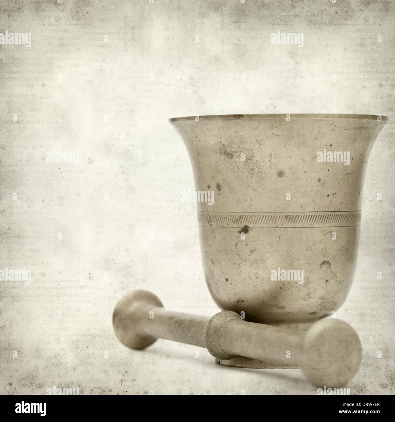 textured old paper background with copper mortar and pestle Stock Photo
