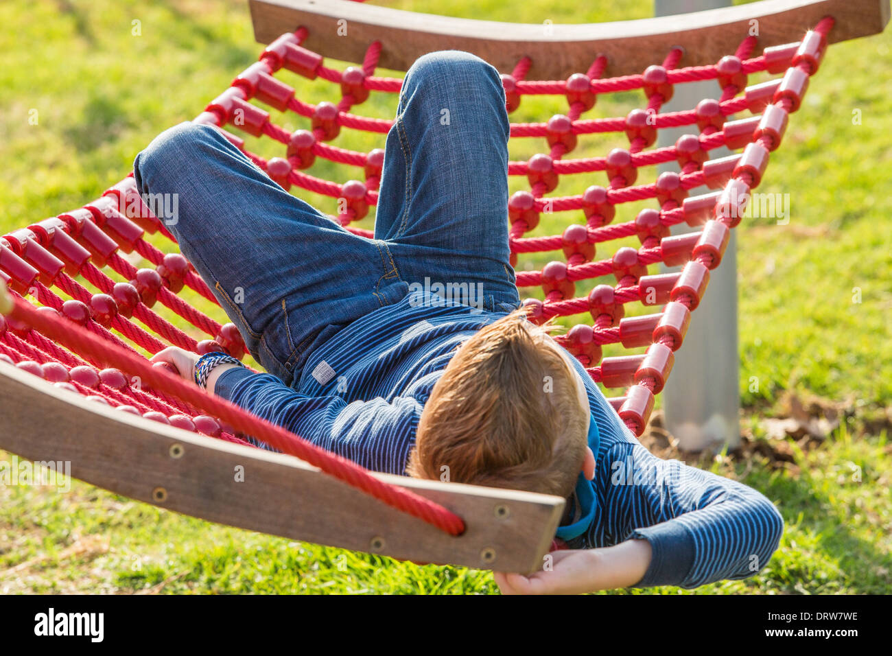 Red haired boy on a hammock in a garden Stock Photo
