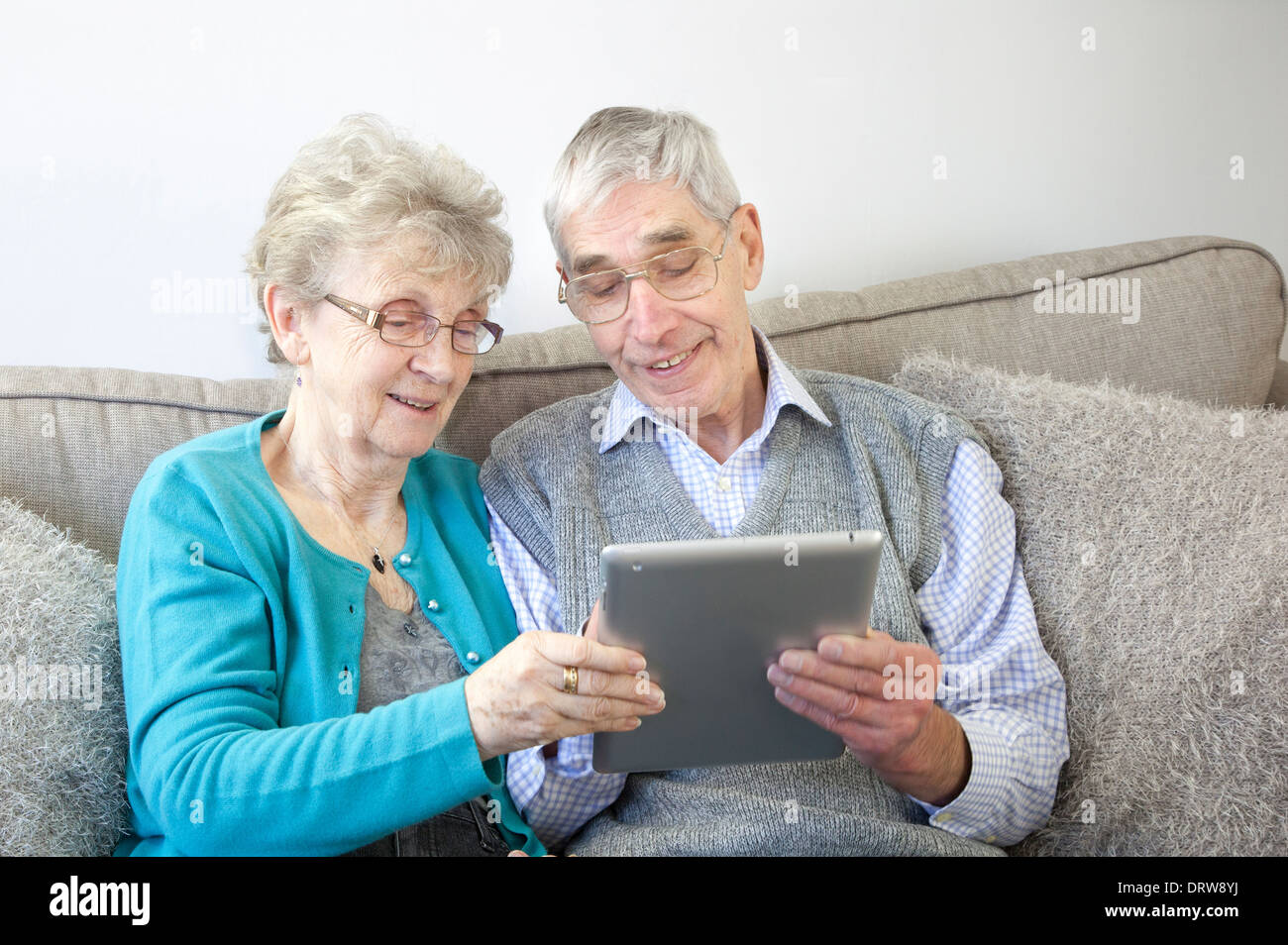Happy senior couple enjoy using a digital tablet at home. Stock Photo