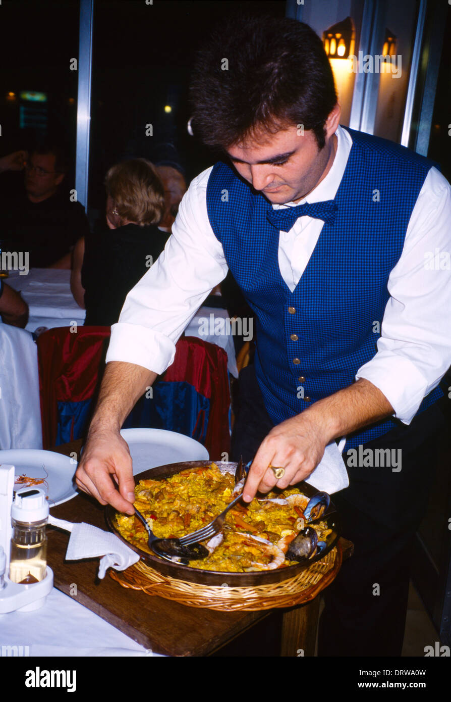Menorca Balearic Islands Spain Sant Tomas Restaurant waiter Serving Paella Stock Photo