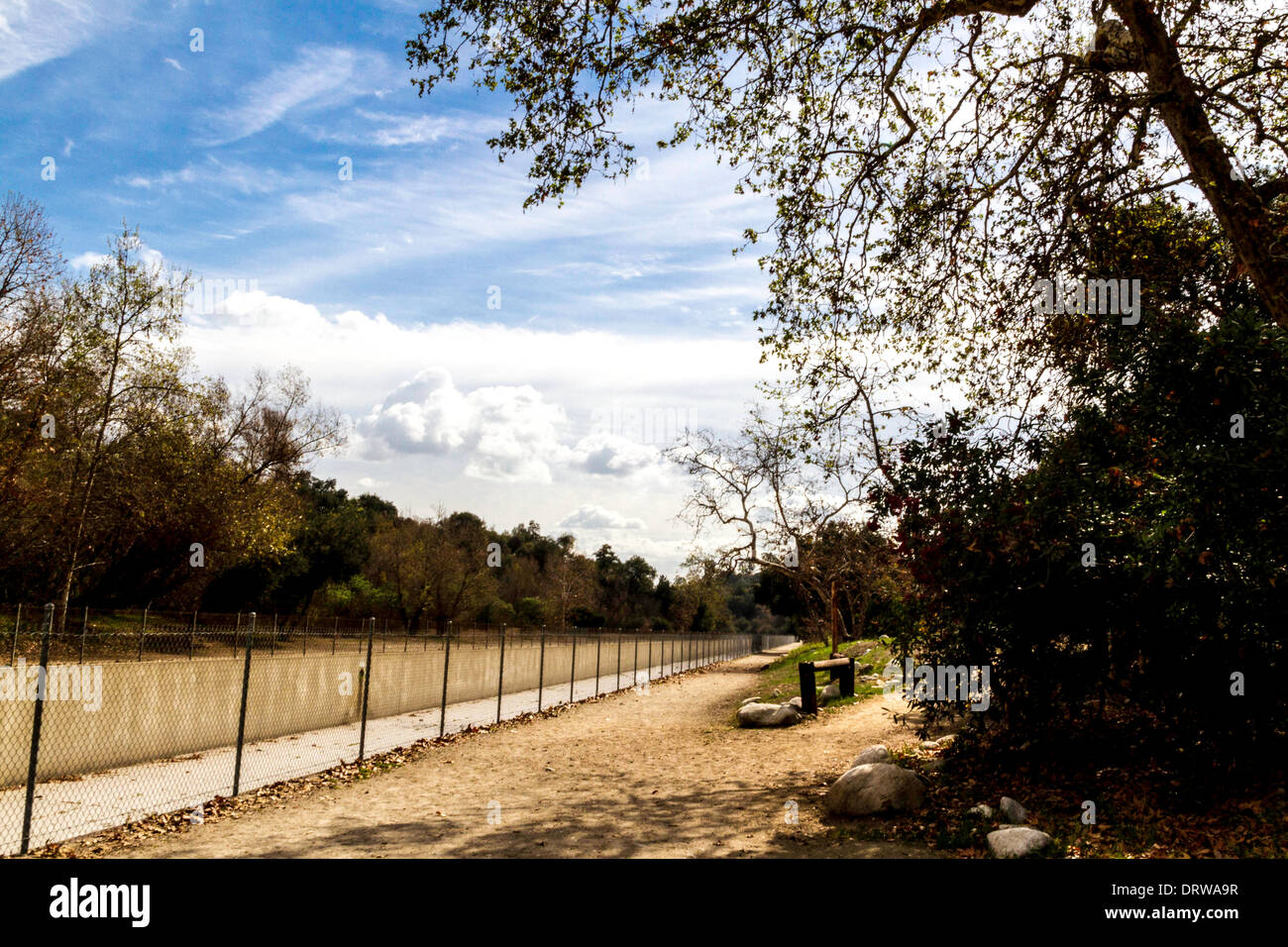 The concrete channel that contains the Arroyo Seco waterway in Pasadena California with the Arroyo hiking trail foreground Stock Photo