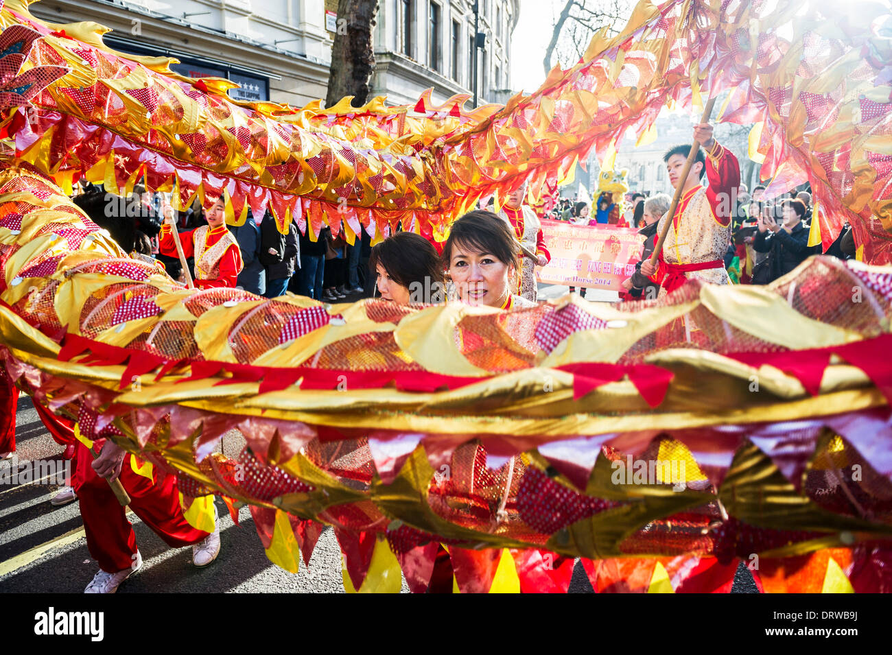 Charing Cross Rd, London, UK. 2nd February 2014. A female dragon dancer working the spectacular dragon during the Chinese New Year parade. Credit:  Gordon Scammell/Alamy Live News Stock Photo