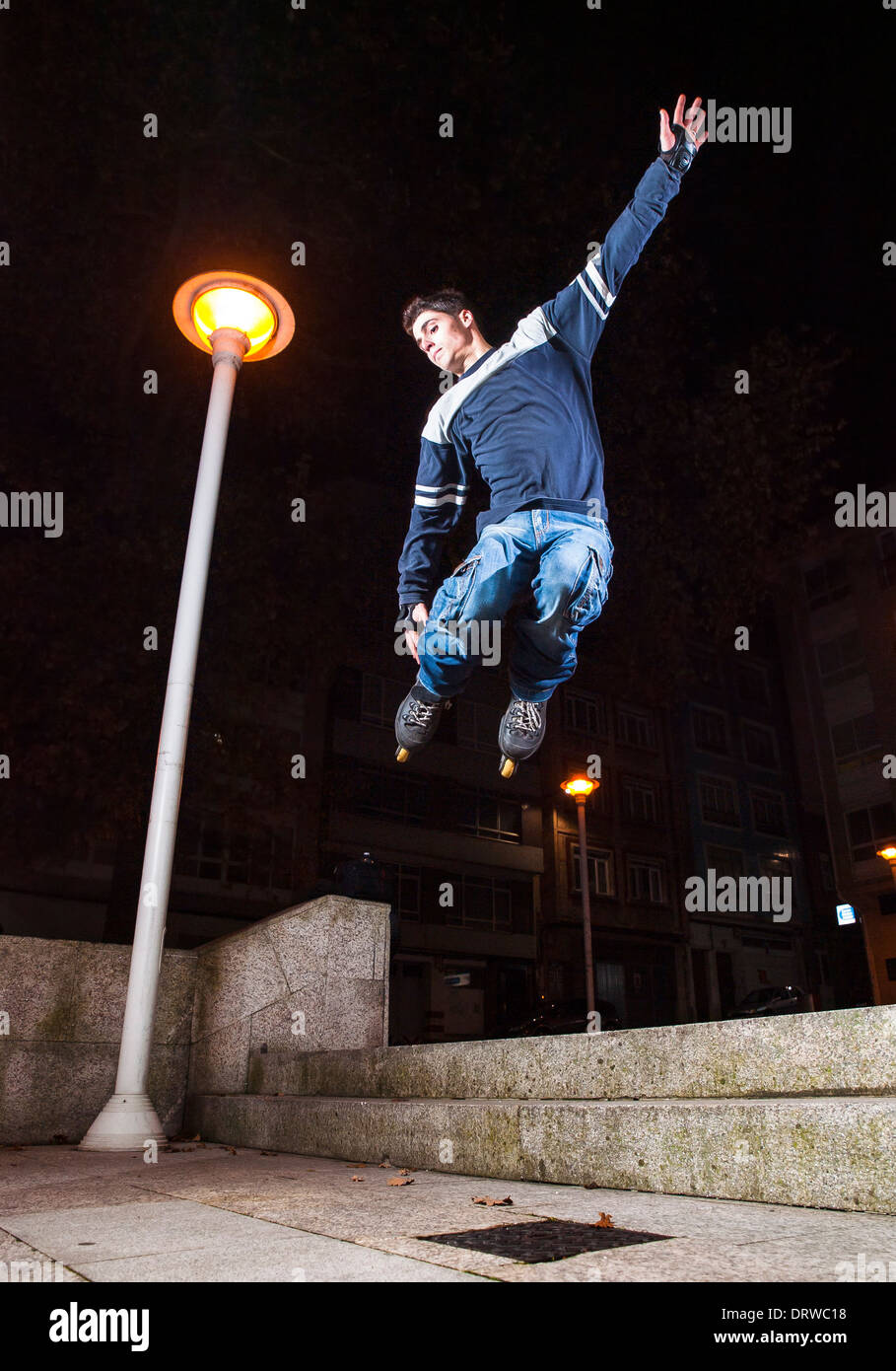 Young man practicing rollerskating. The young is grind a railing. Stock Photo