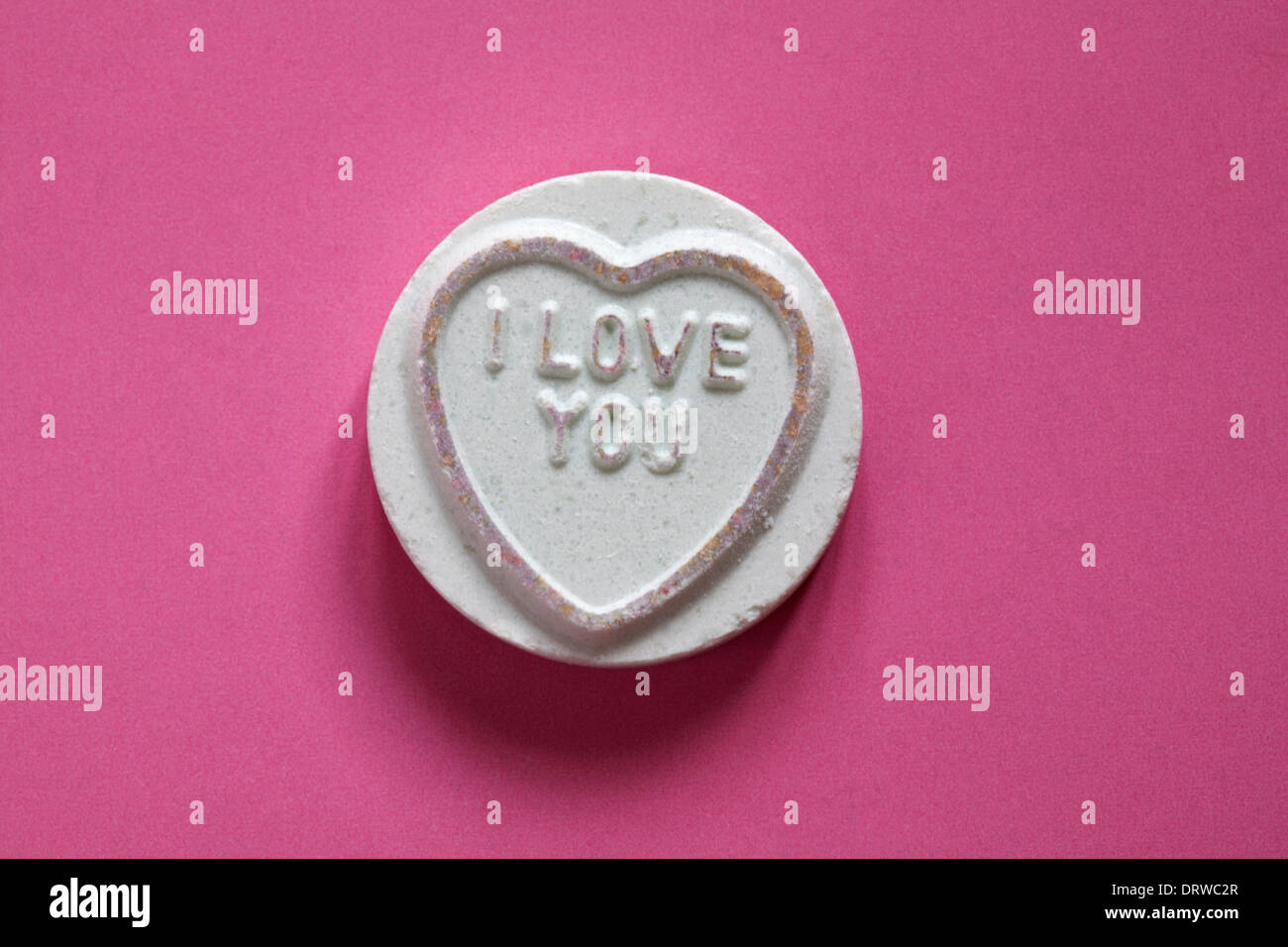 Swizzels Matlow Giant Love Hearts - individual sweet with I Love you isolated on pink background - Valentine Day message - loveheart sweets Stock Photo