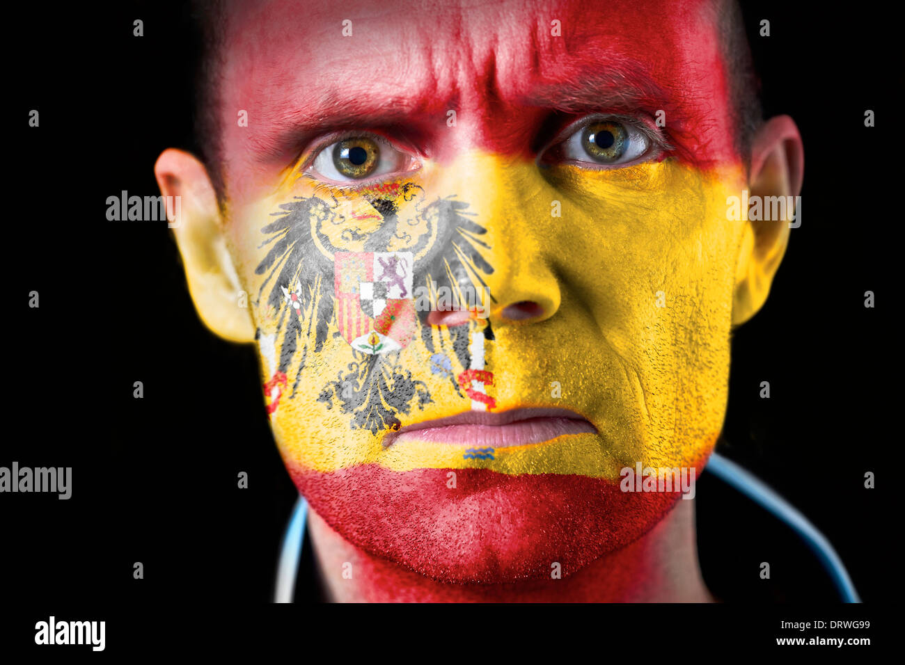 An intense stare from a football fan with their face painted with the Spanish flag Stock Photo