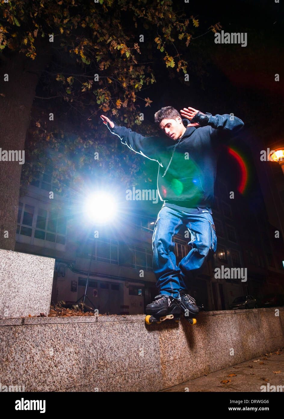 Young man practicing rollerskating. The young is grind a curb. Stock Photo