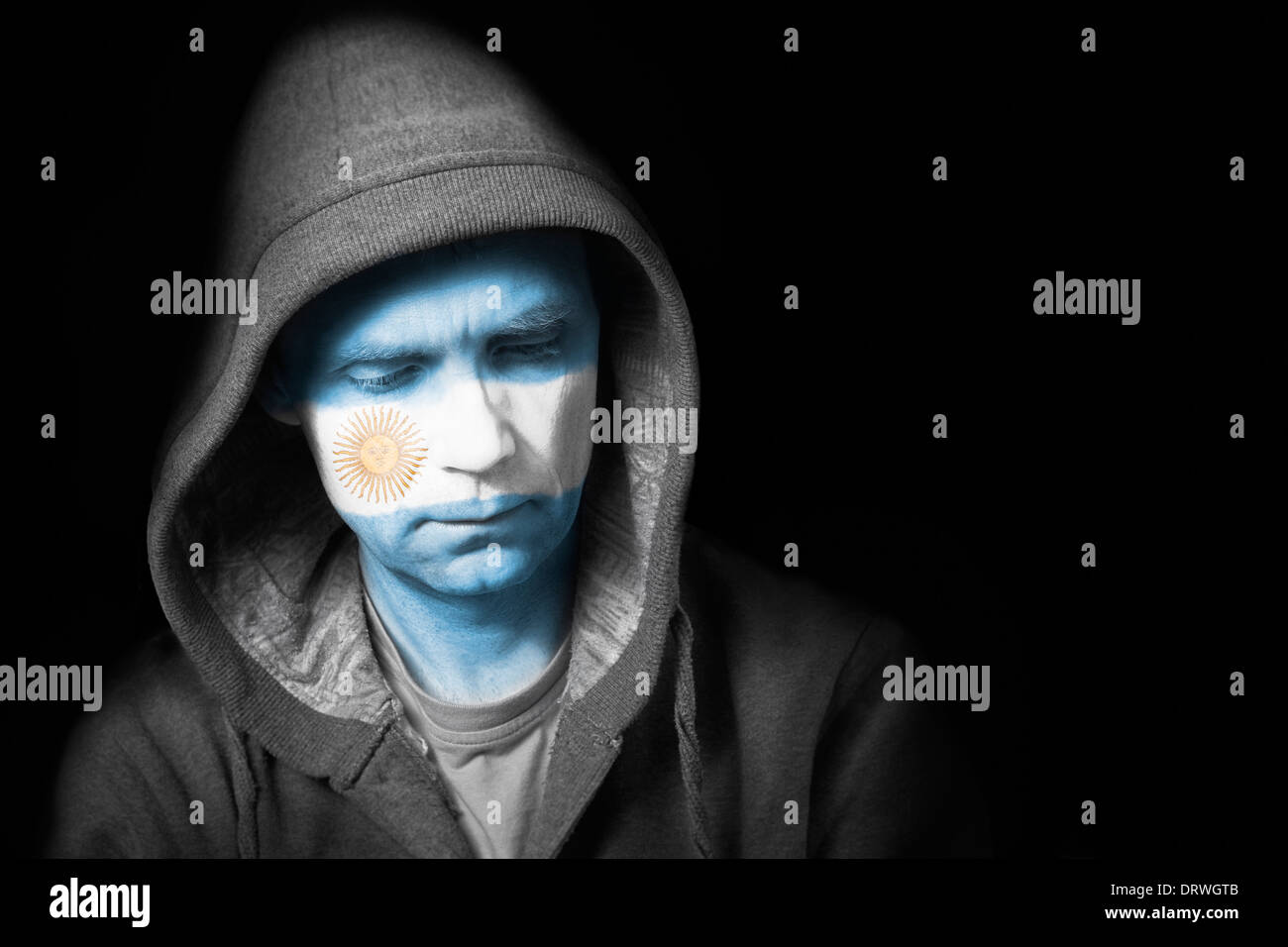 A sad expression on the face of a football fan with their face painted with the Argentinian flag. Stock Photo