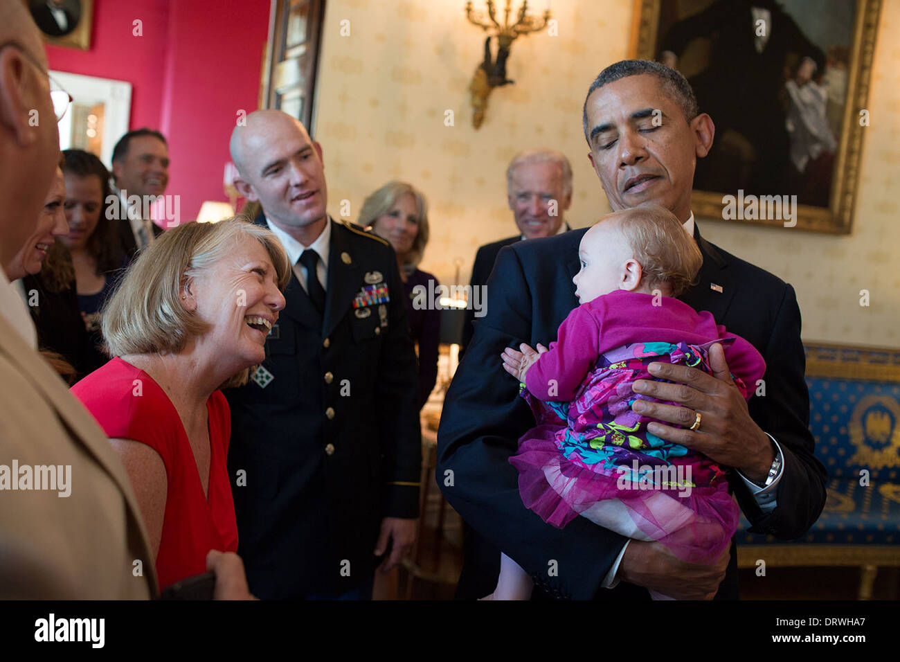 US President Barack Obama visits with U.S. Army Staff Sergeant Ty Carter and family in the Blue Room of the White House prior to the Medal of Honor ceremony honoring Carter August 26, 2013 in Washington, DC. The President holds Carter's daughter Sehara. Stock Photo