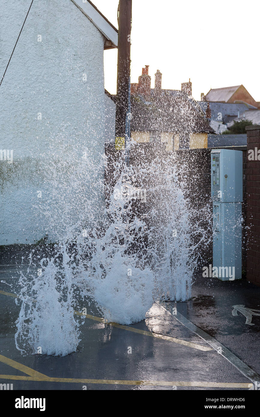 Sea water surging through drain covers in the car park at Watchet