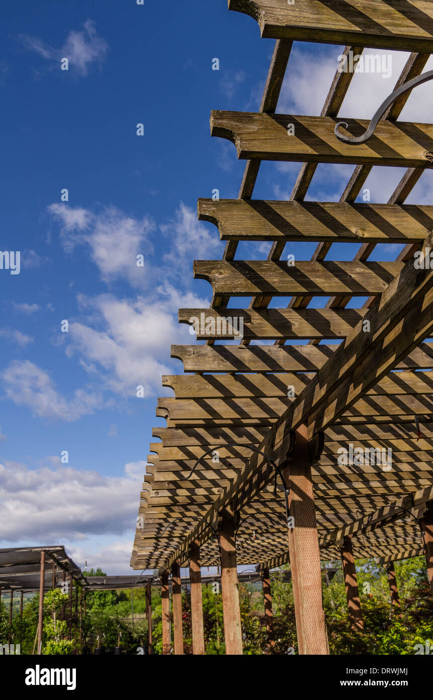 A wooden pergola provides shade for plants in a retail nursery.  Medford, Oregon Stock Photo