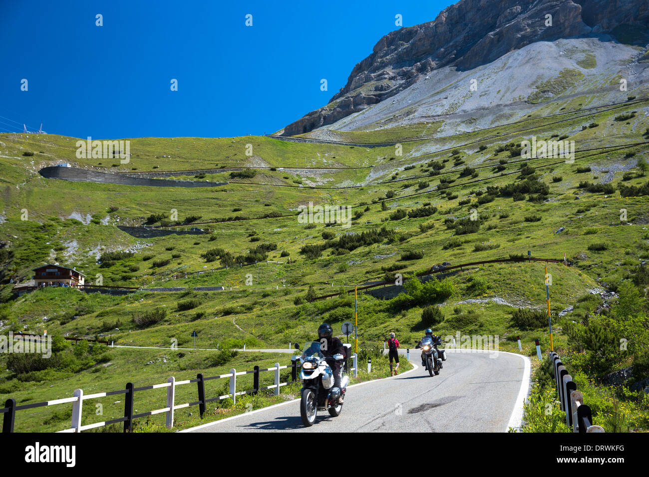 Motorcycles and walker on Stelvio Pass, Passo dello Stelvio, Stilfser Joch, on route Trafoi to Bormio, the Alps, Northern Italy Stock Photo