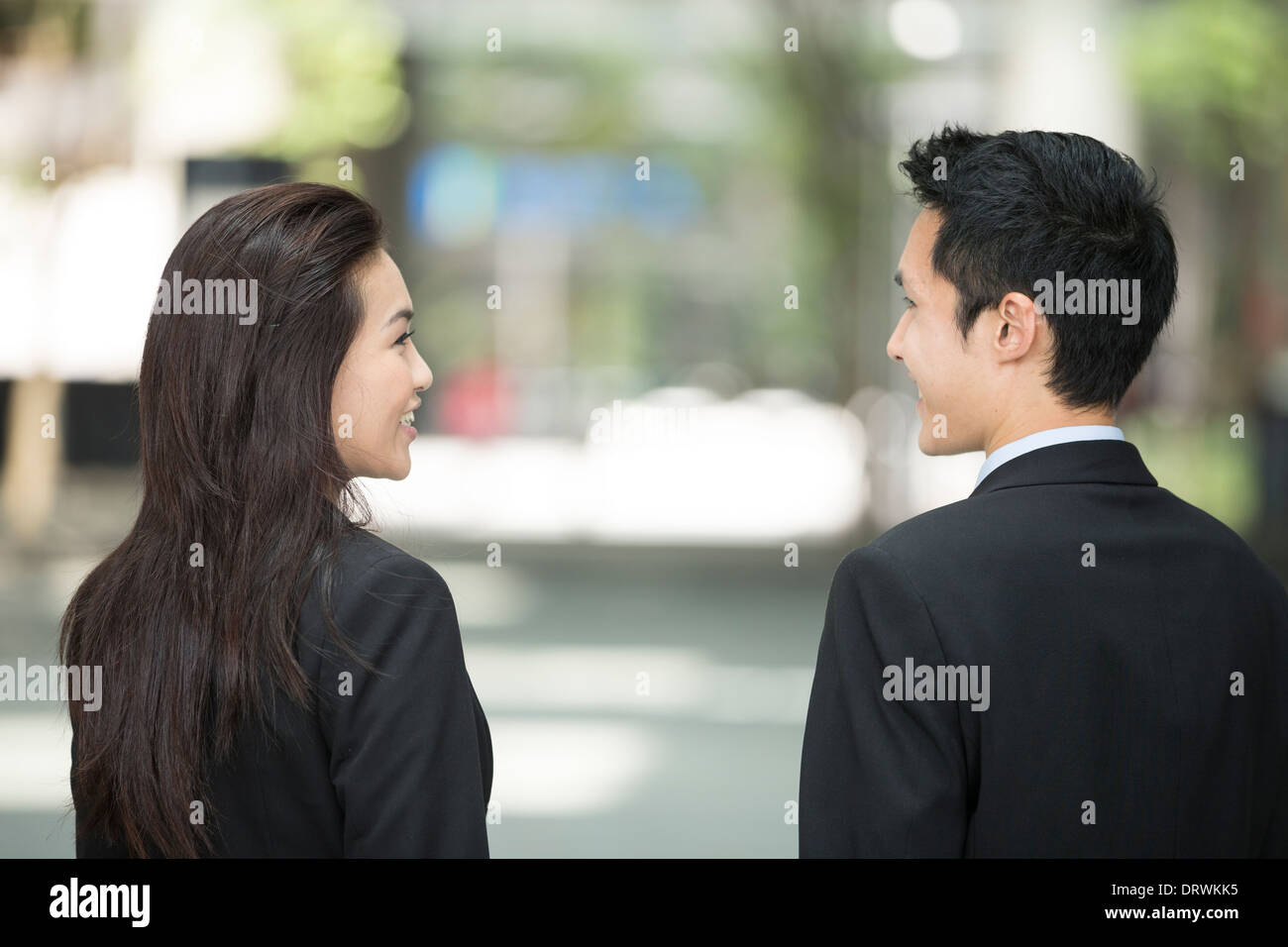 Happy Chinese Business colleagues outside the office talking to each other. Stock Photo