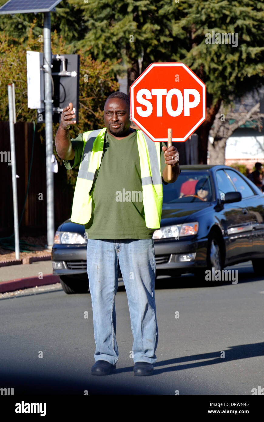 school crossing guard directs traffic on San Rafael California street Stock Photo