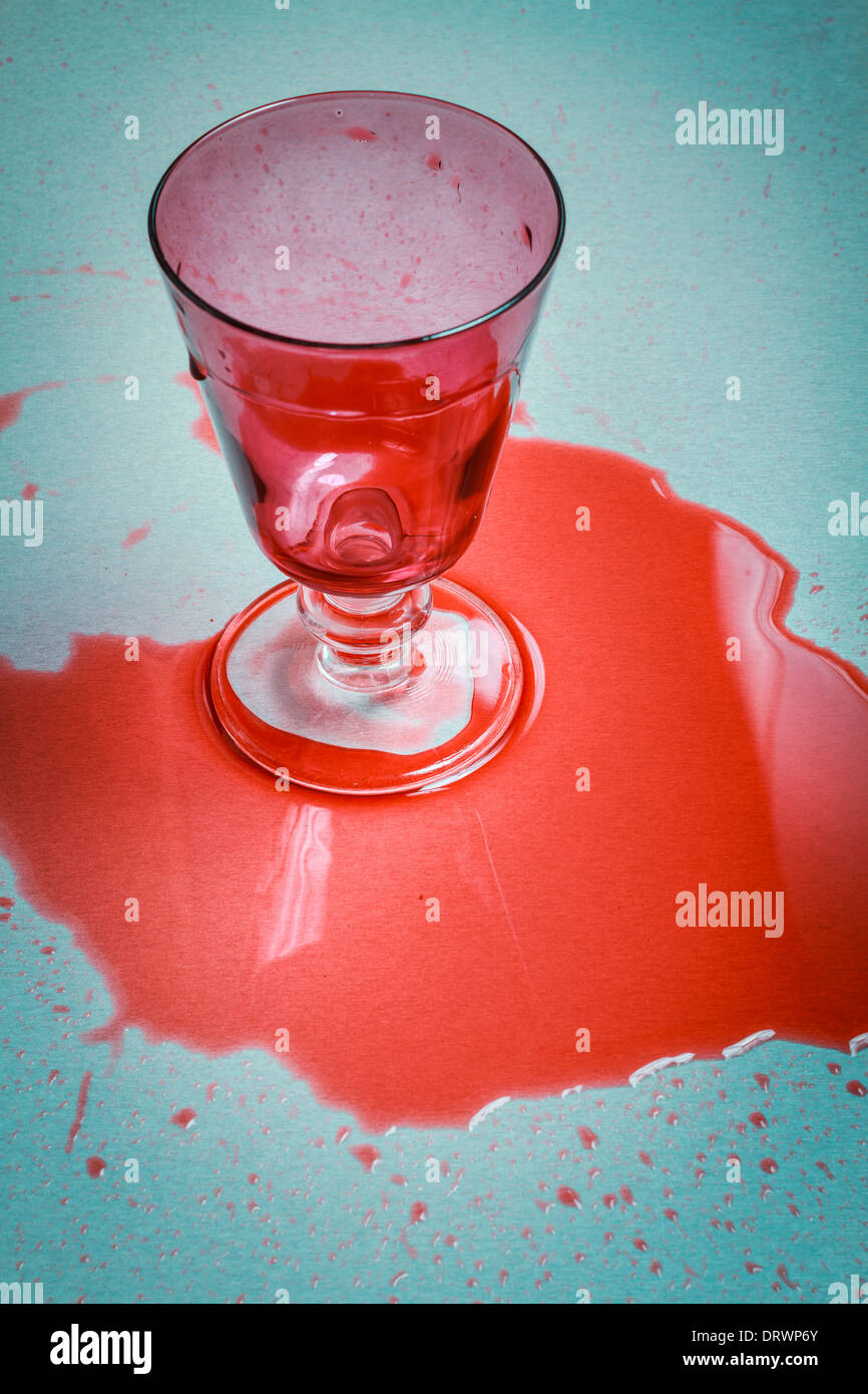 Glass of spilt red wine on table. Stock Photo