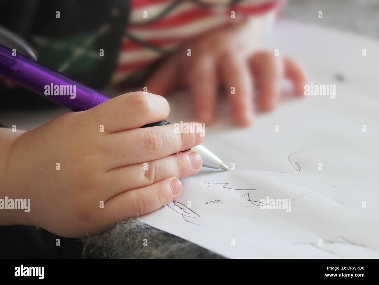 small child's hand writing in notebook Stock Photo