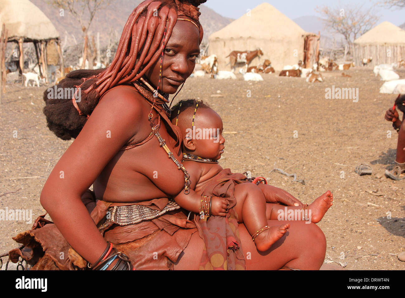 Himba tribe mother with her baby on her lap in a  Himba village,Namibia,Africa. Stock Photo