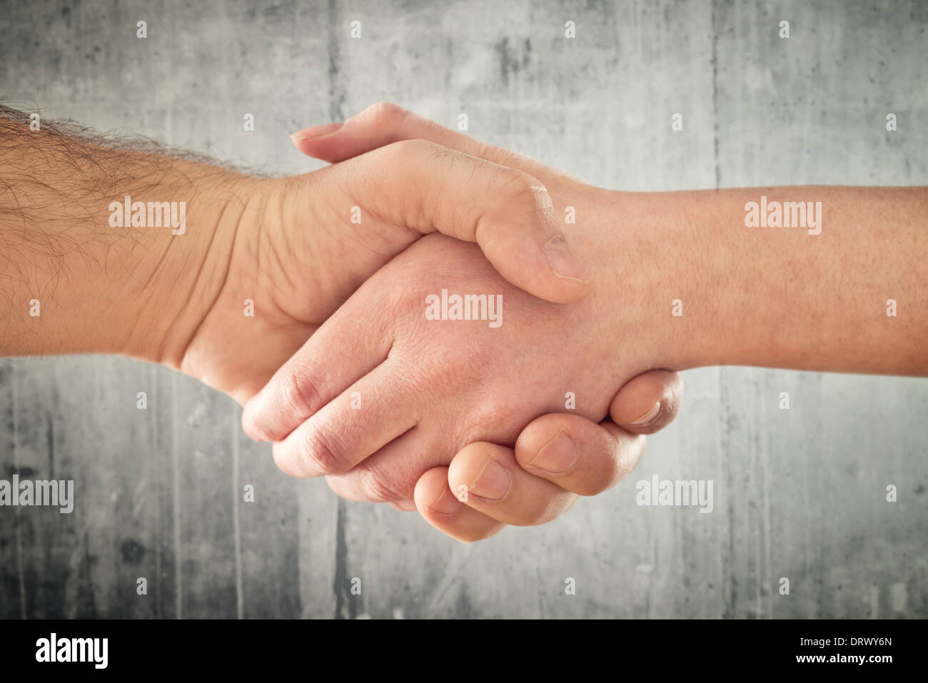 Friendly handshake. Man and woman shaking hands as welcoming gesture. Stock Photo