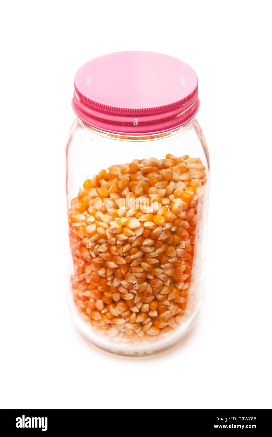 Jar of popcorn kernels isolated on a white studio background Stock