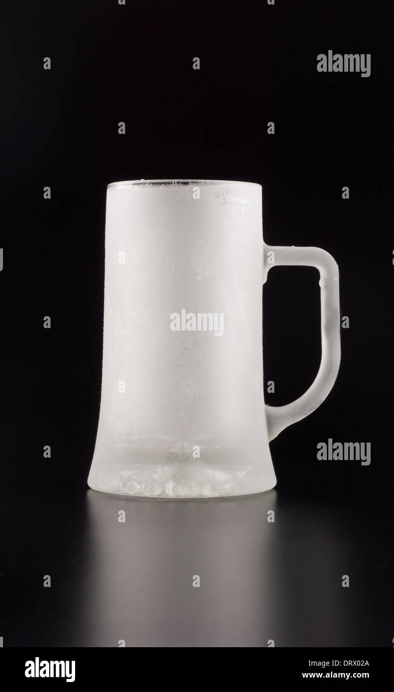 An empty and frozen glass tankard over black background Stock Photo