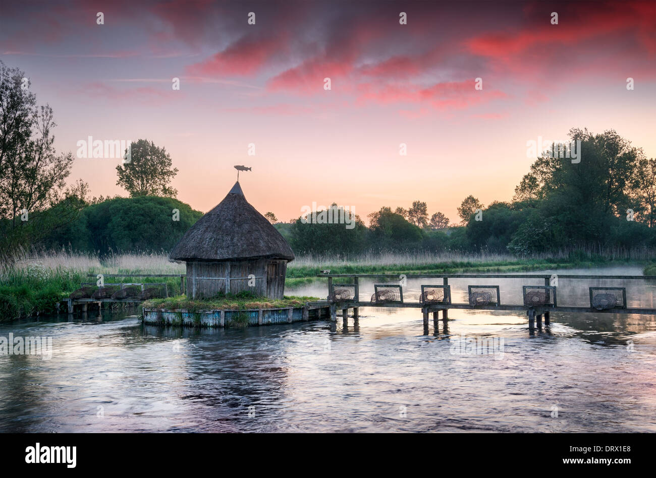 Thatched fisherman's hut and traditional eel traps on the River Test in Hampshire Stock Photo