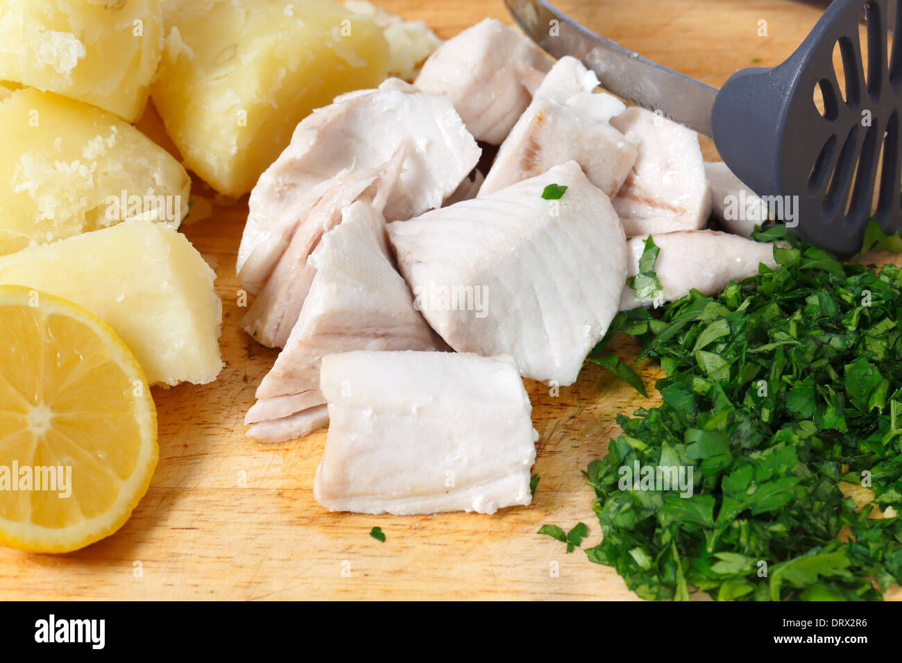 Steamed kingfish chunks with boiled potatoes and parsley, ready to be mashed with lemon peel into homemade fishcake mixture. Stock Photo
