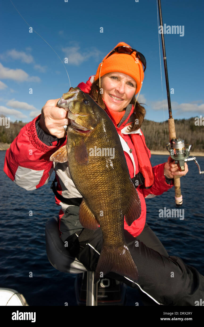 Woman angler holding up a huge smallmouth bass caught from a boat on a lake  in Northern Ontario Stock Photo - Alamy