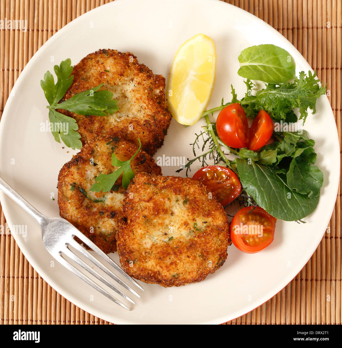 Easy to make fishcakes,  steamed fish crumbled into mashed potato and parsley, thickened with flour, rolled in breadcrumbs Stock Photo