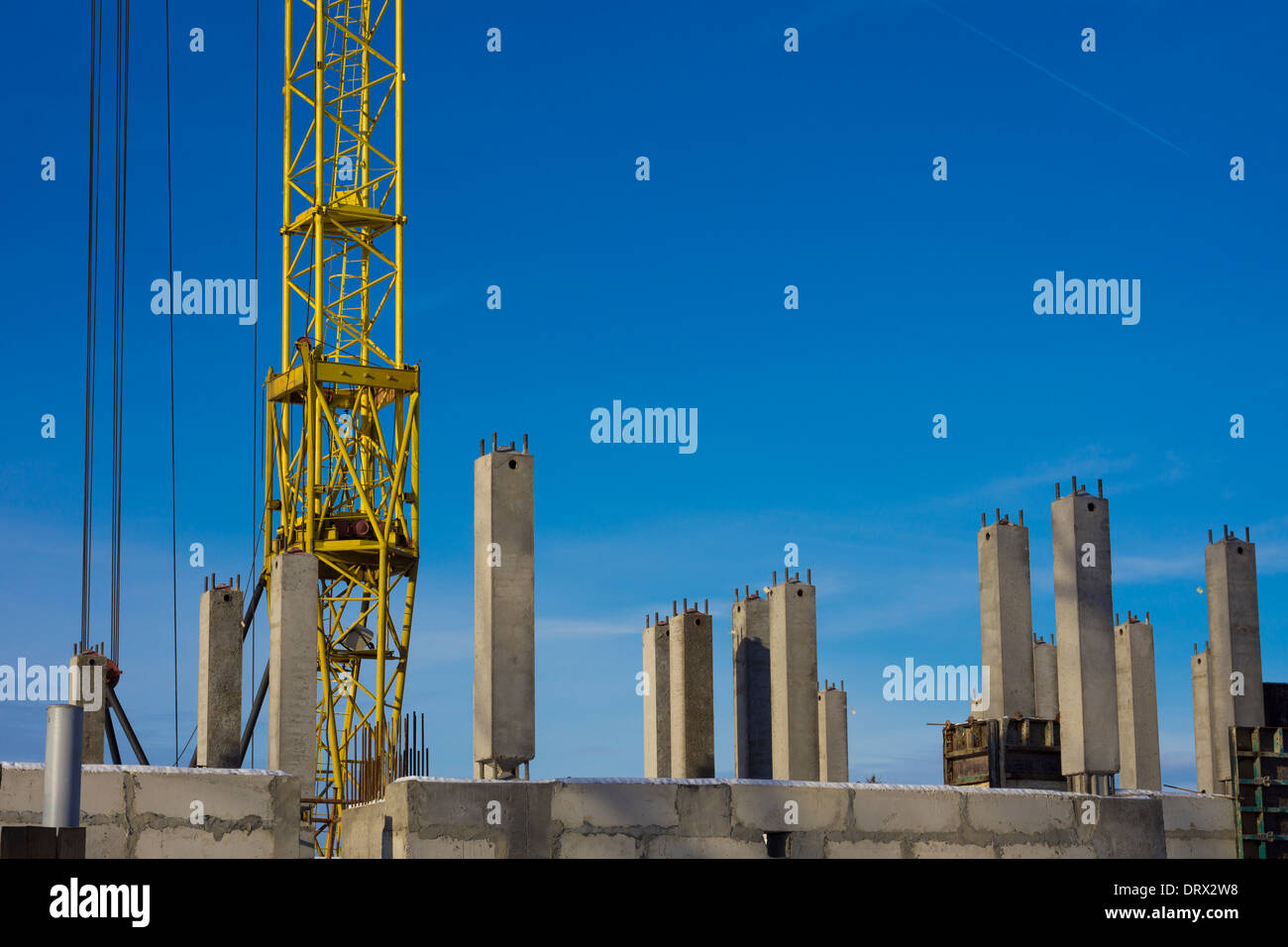 Bottom of tower crane on construction site between concrete piles. Stock Photo