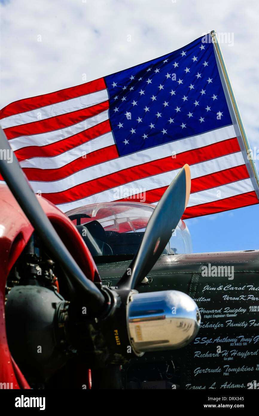 An American flag flies over a WW2 B24 Liberator bomber plane Stock Photo